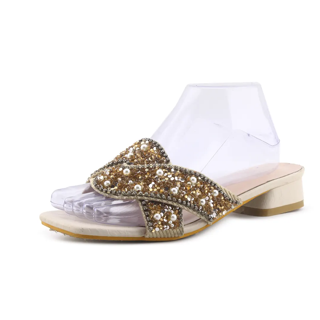 White sandal with gold embellishments on a white background